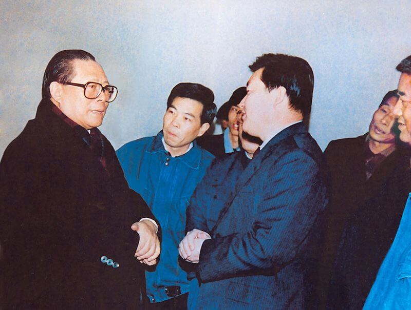 1991年2月5日，时任中共中央总书记的江 泽 民（左一）视察QY千亿国际，他指示：“抓住机遇，深化改革，扩大开放，促进发展，保持稳定。”
